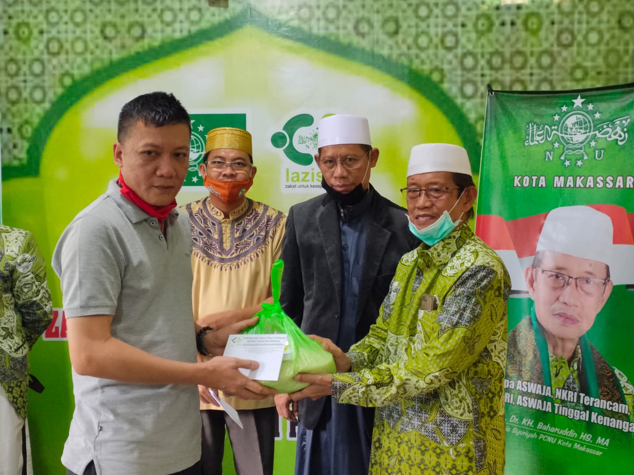 Rais Syuriyah Pengurus Cabang Nahdatul Ulama (PCNU) kota Makassar AGH. Baharuddin HS serahkan zakat fitrah secara simbolis kepada mustahiq (Foto:Ist)