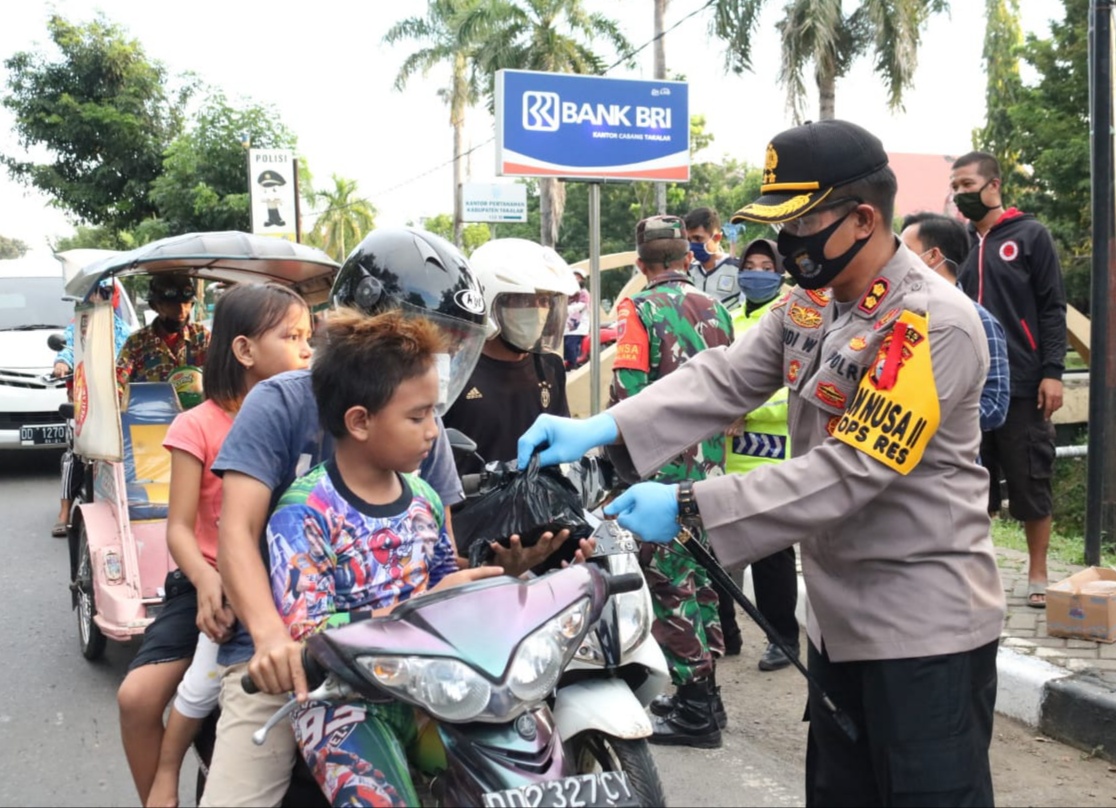 Kapolres Takalar AKBP Budi Wahyono bagi takjil kepada pengendara di jalan Jenderal Sudirman Takalar, Selasa (05/05/2020)