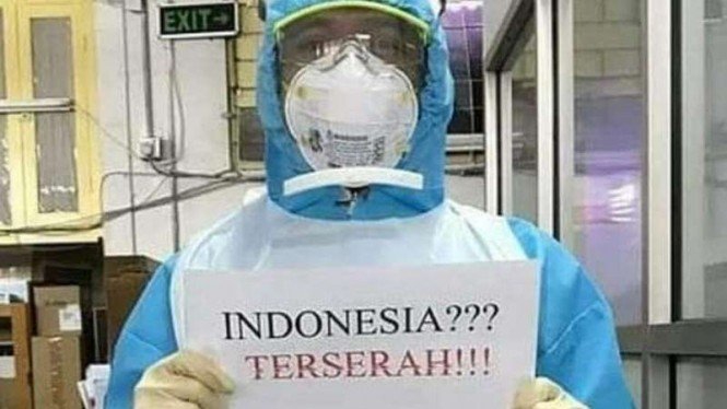 Salah satu tim medis yang memegang poster Indonesia terserah yang ramai di media sosial
